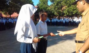 Kepala SMPN 1 Wawo, Mulyadin, saat menyerahkan buku tabungan kepada siswa. Dalam waktu kurang dari satu bulan, tabungan siswa mencapai Rp5,7 juta.