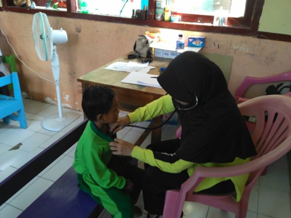 Dokter saat memeriksa kesehatan salah seorang siswa.